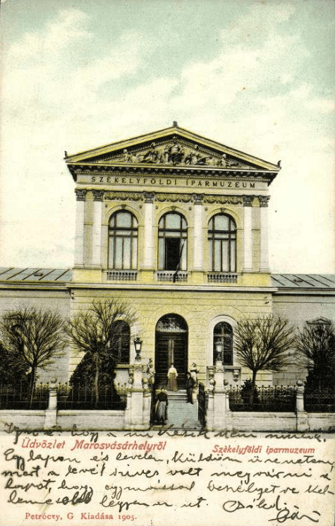 Carte poștală colorată: fațada principală, cu frontonul sculptat și inscripția SZÉKELYFÖLDI IPARMUZEUM